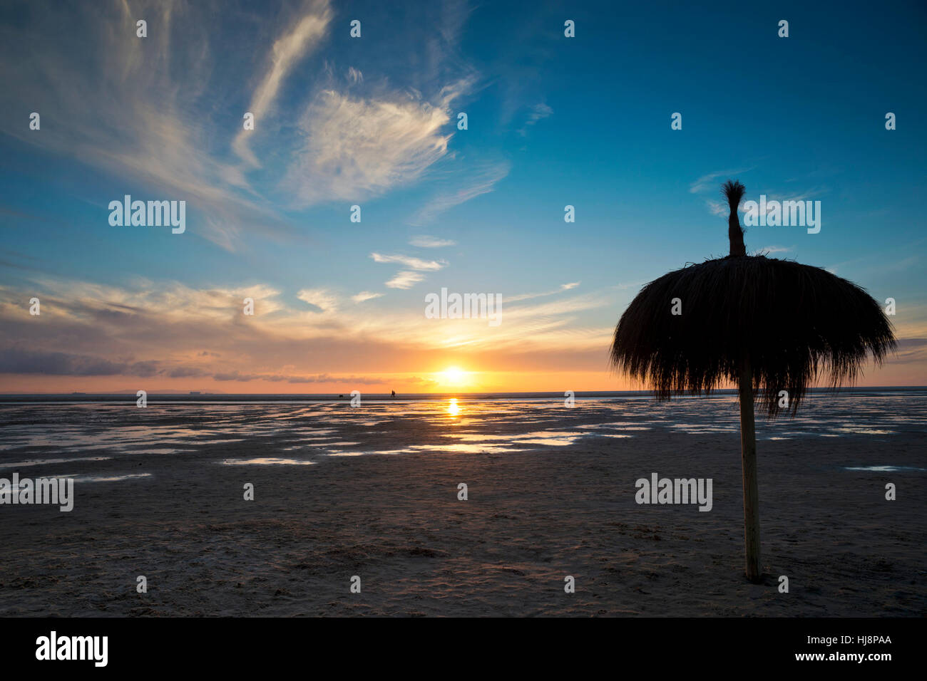 Sonnenschirm am Strand Los Lances bei Sonnenuntergang, Tarifa, Cádiz, Andalusien, Spanien Stockfoto