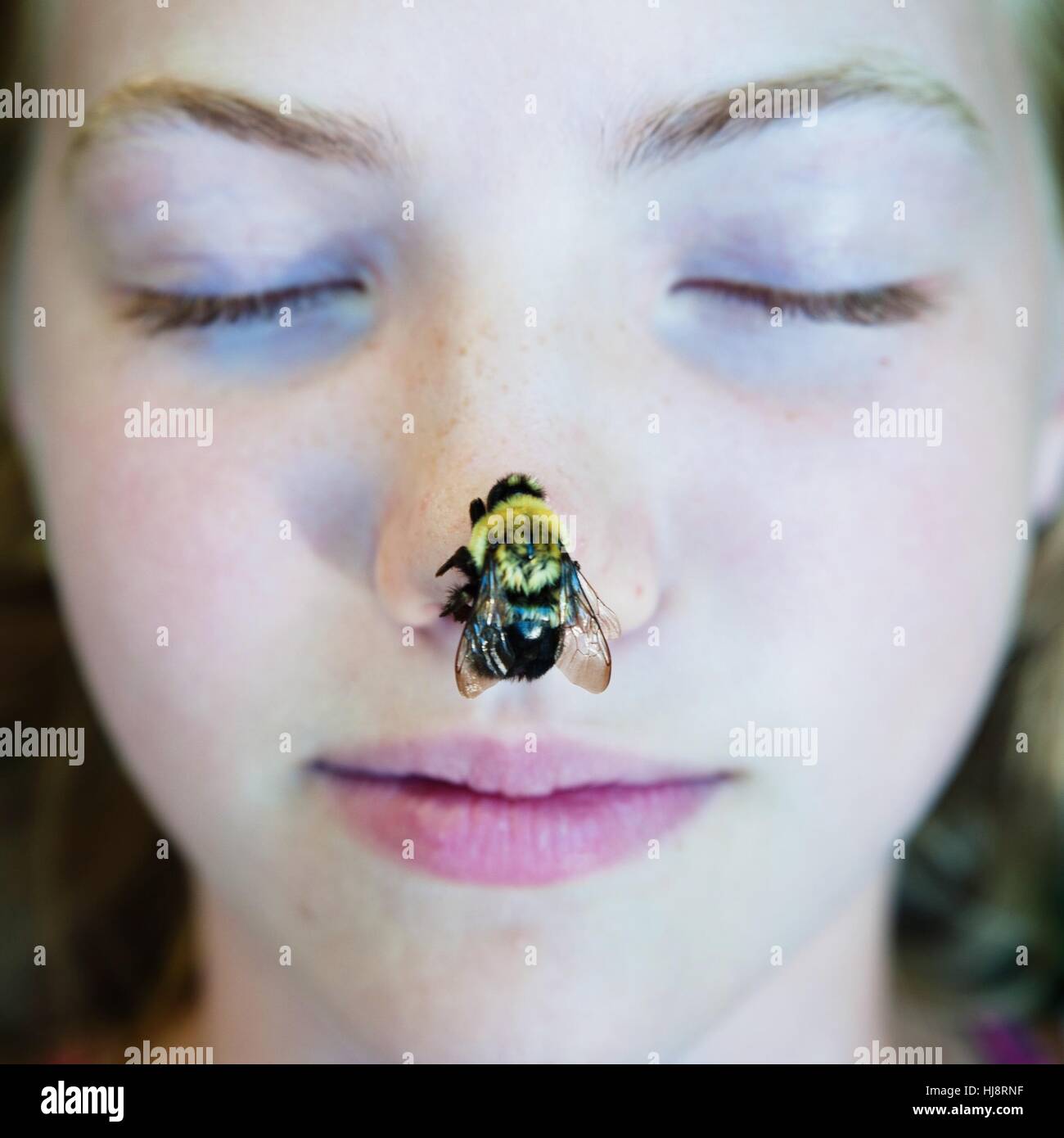 Mädchen mit einer Biene auf der Nase Stockfoto
