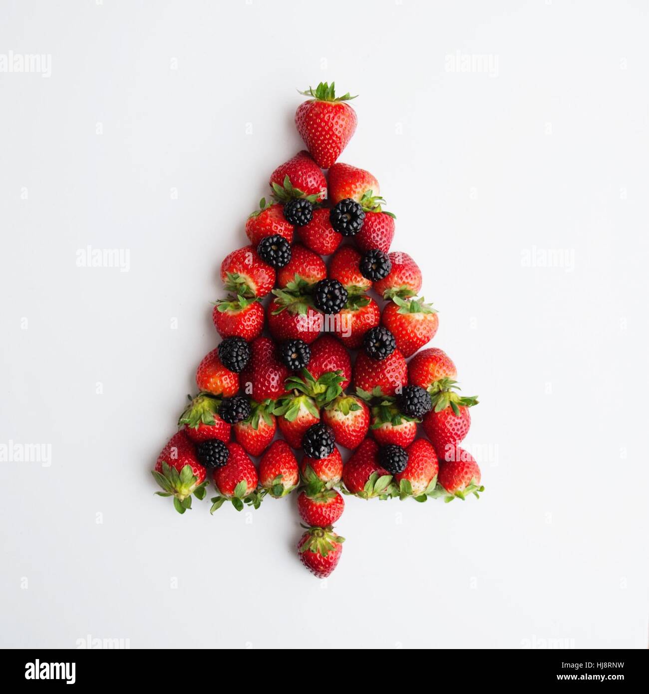 Erdbeeren und Brombeeren in Form eines Weihnachtsbaumes Stockfoto