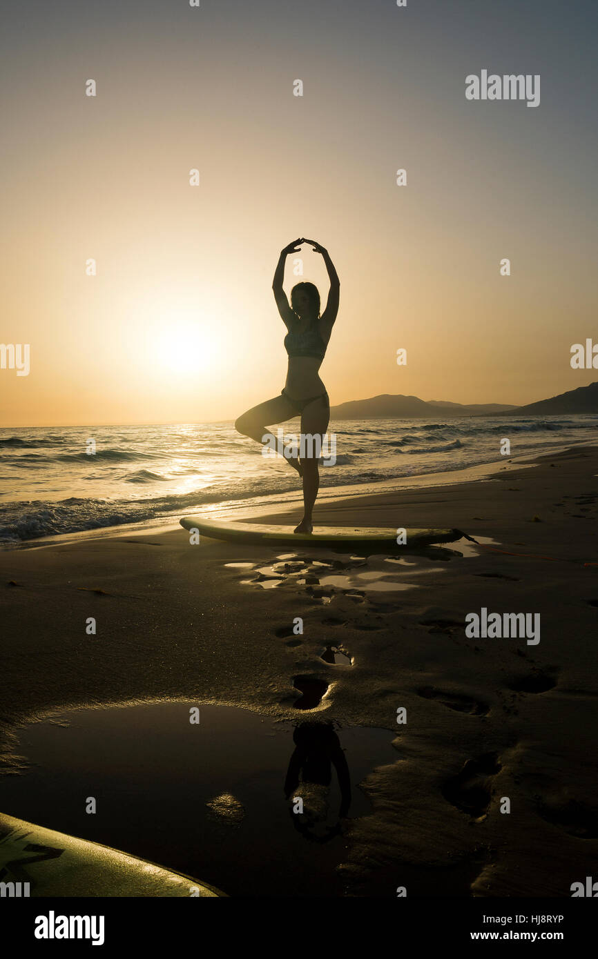 Silhouette einer Frau stehend auf Surfbrett, Los Lances Strand, Tarifa, Cadiz, Spanien Stockfoto