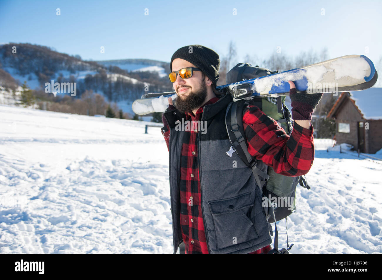 Bärtiger Mann mit Skiern auf dem schneebedeckten Berg Stockfoto