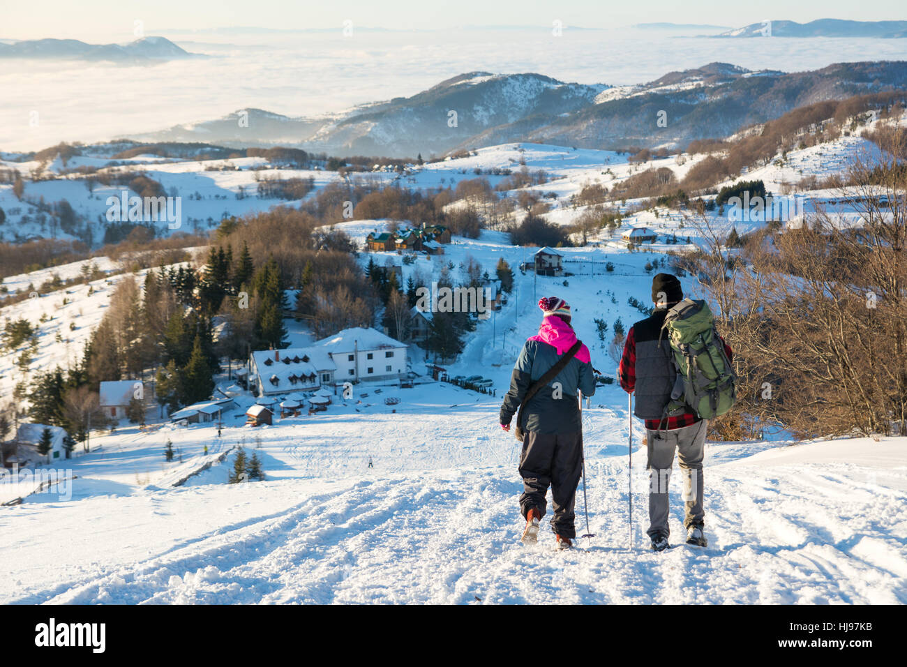 Paar der Wanderer zu Fuß den verschneiten Berg hinunter Stockfoto