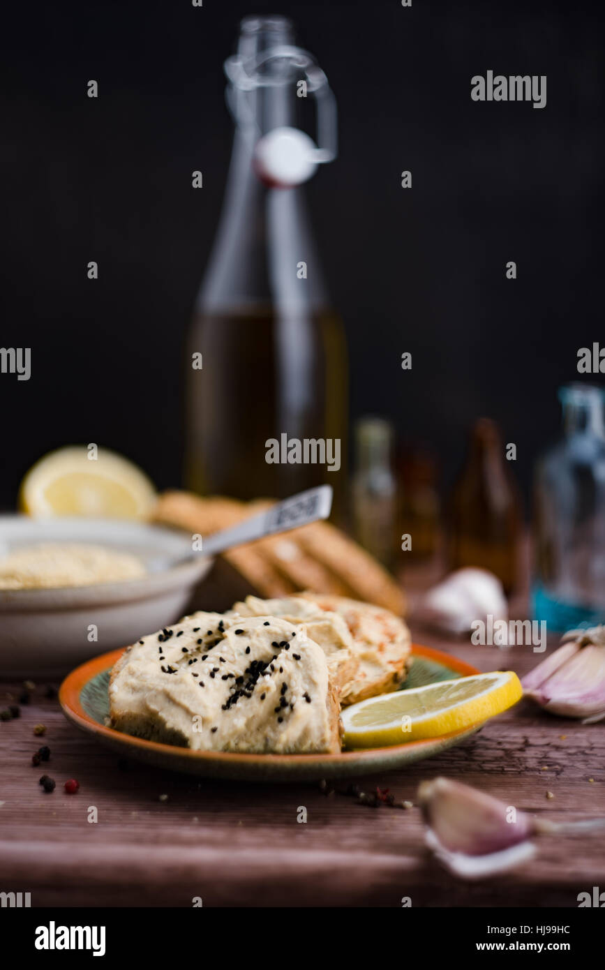 Hummus und Zutaten im rustikalen Stil. Stockfoto