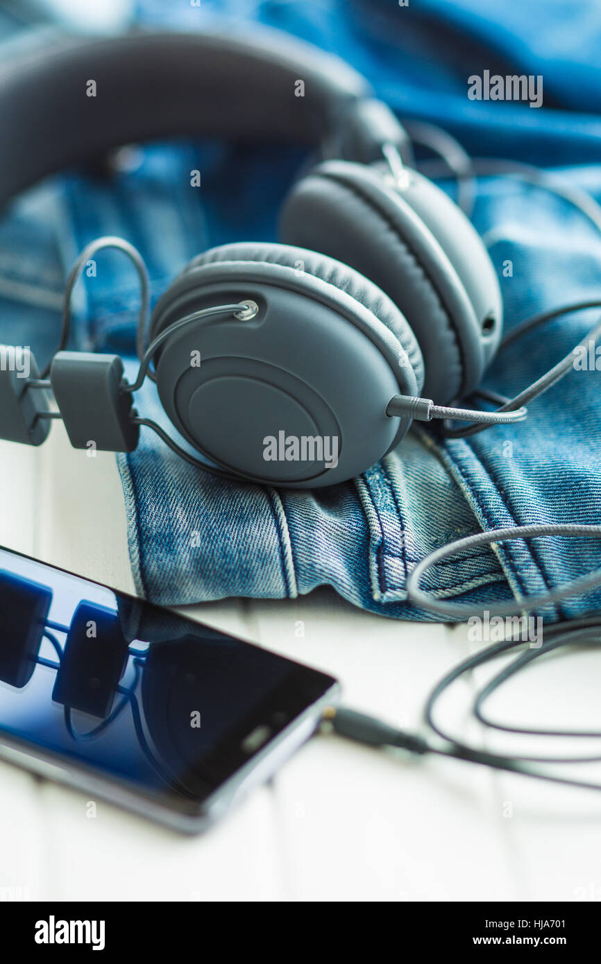 Die Kopfhörer, Handy und blaue Jeans. Stockfoto