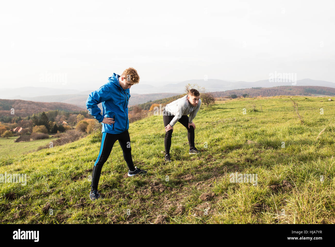 Zwei junge Hipster-Läufer im sonnigen Herbst Natur restinng Stockfoto