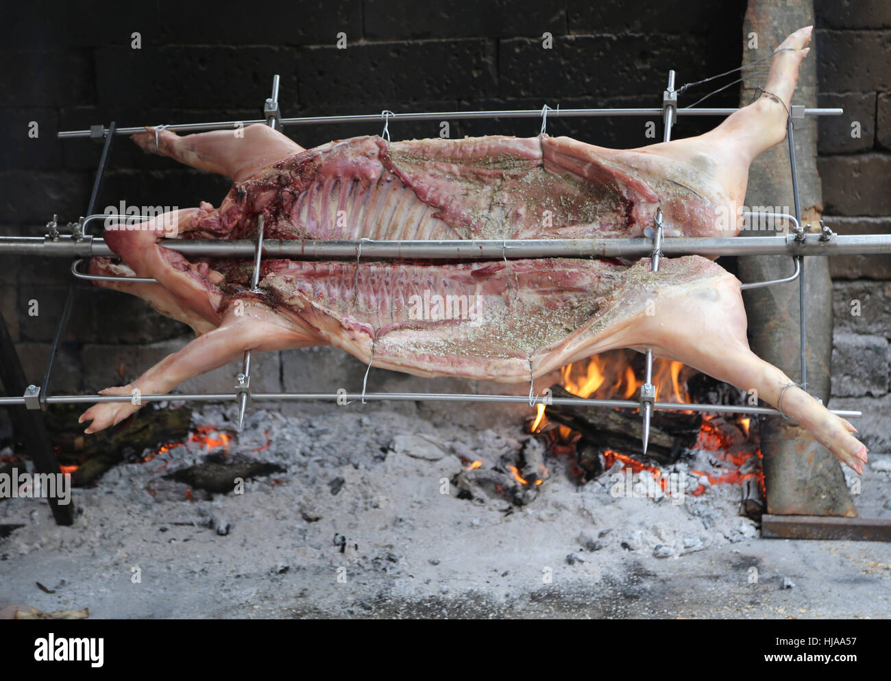 großen Schwein am Spieß und auf dem großen Kamin gekocht Stockfoto