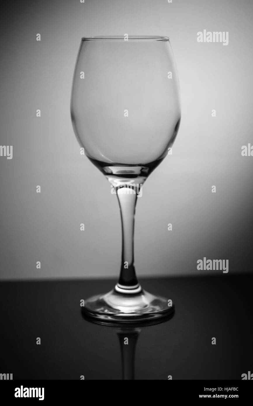 Leere Glas Wein stehen auf dunkle reflektierende Oberfläche Stockfoto