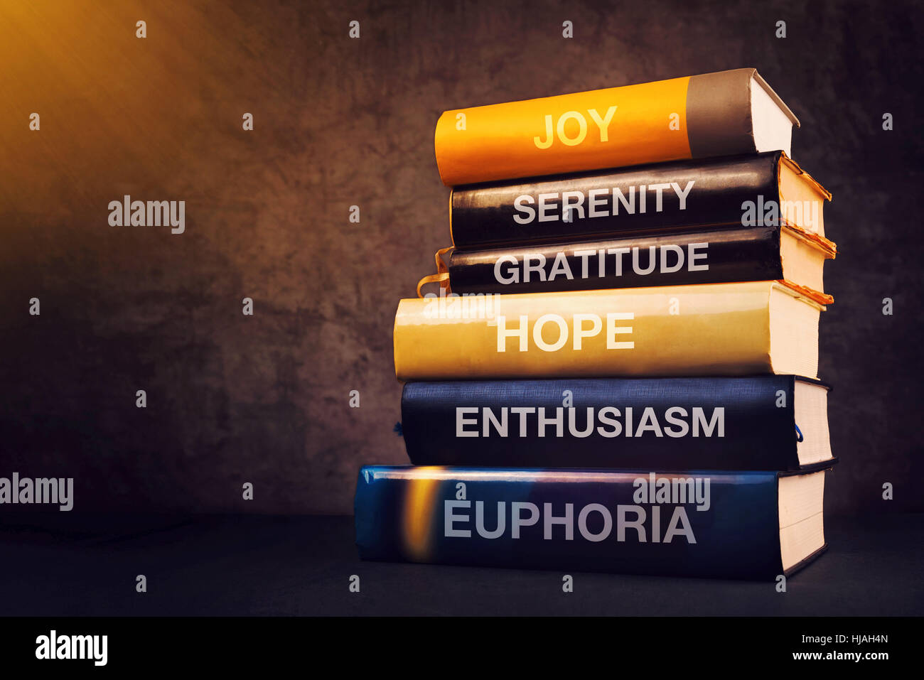 Positive Emotionen und Gefühle-Konzept mit Buchtitel auf Bibliothek Regal - Freude, Gelassenheit, Dankbarkeit, Hoffnung, Begeisterung und Euphorie Stockfoto