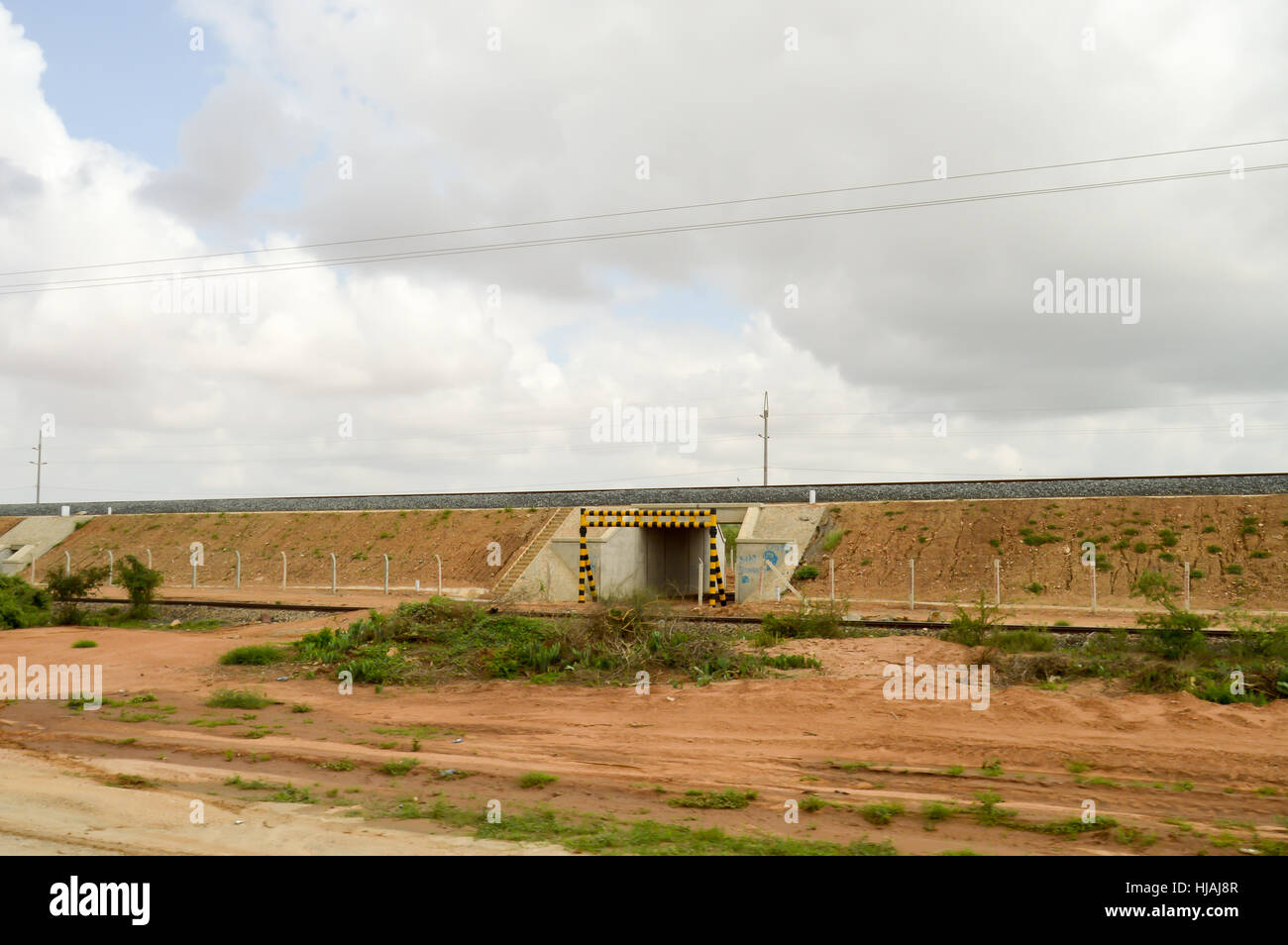 Durchfahrt von Fahrzeugen unter der Eisenbahnlinie von Mombasa nach Nairobi mit einer Höhe Steuerleiste in Kenia Stockfoto