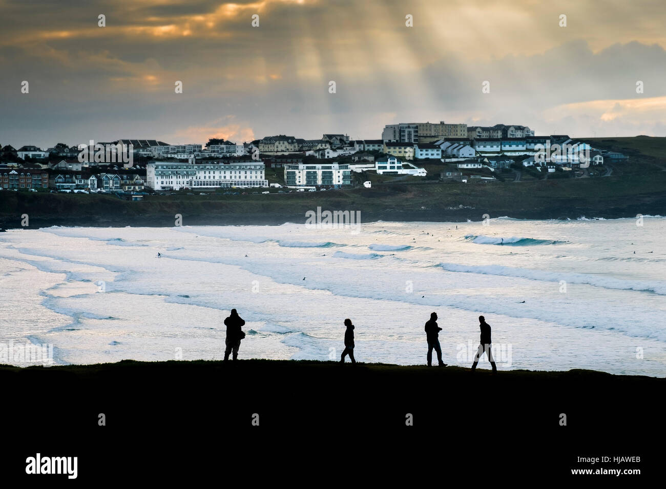 Menschen in der Silhouette zu sehen, wie sie Fuß entlang der Küste mit Blick auf Fistral Beach in Cornwall, England, UK. Stockfoto