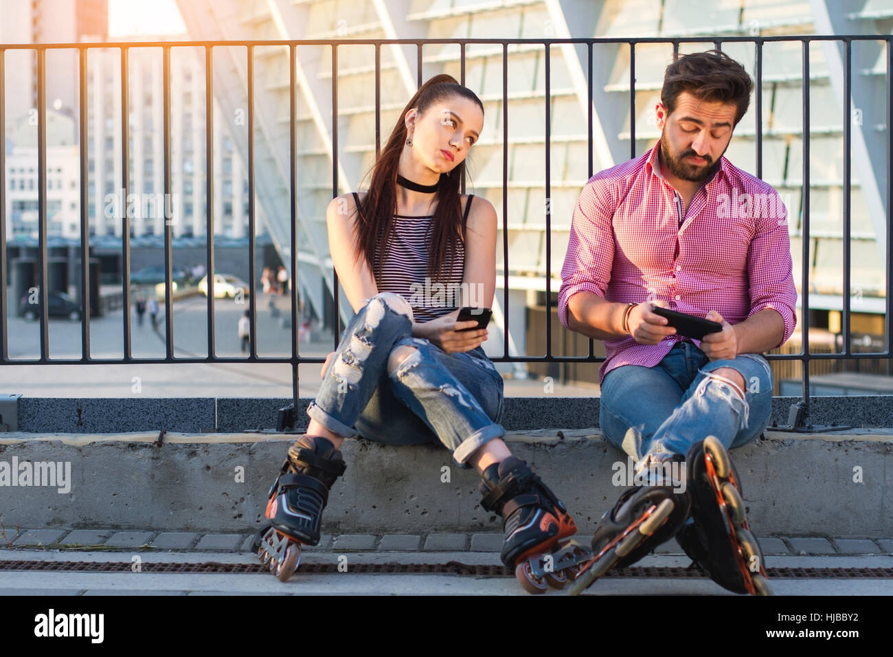 Paar mit Handys sitzt. Stockfoto