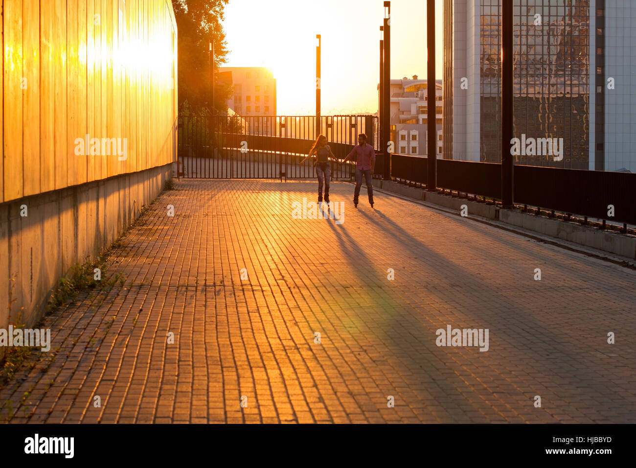 Paar Inlineskater bei Sonnenuntergang. Stockfoto