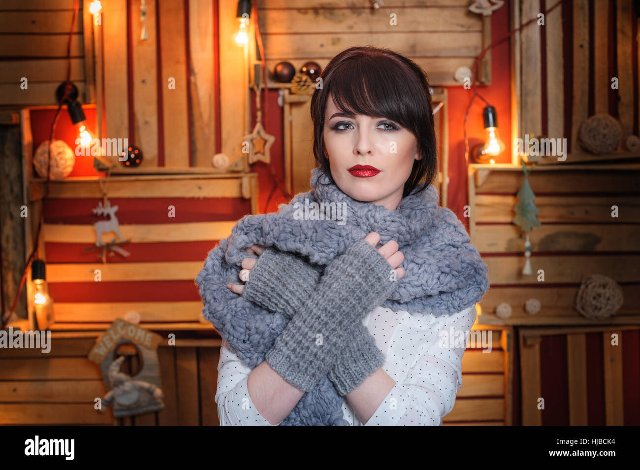 schöne junge Frau mit grauen Schal im Studio Stockfoto