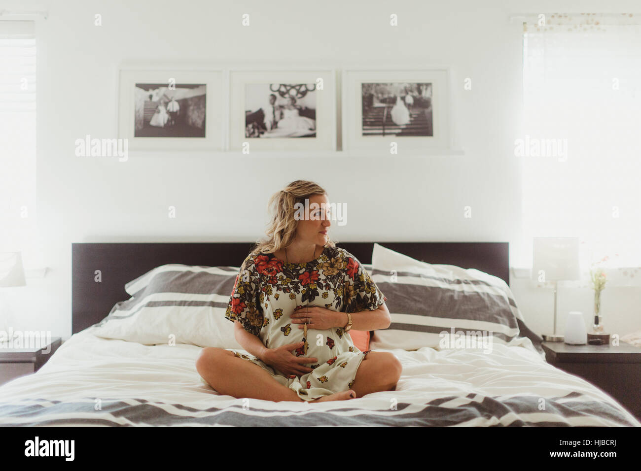 Schwangere Frau auf Bett Bauch zu berühren Stockfoto