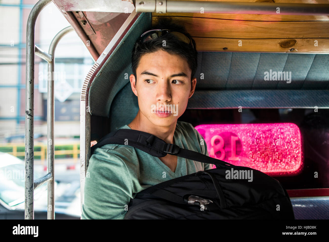 Junger Mann sitzt auf der Rückseite Tuk Tuk, Chiang Mai, Thailand Stockfoto