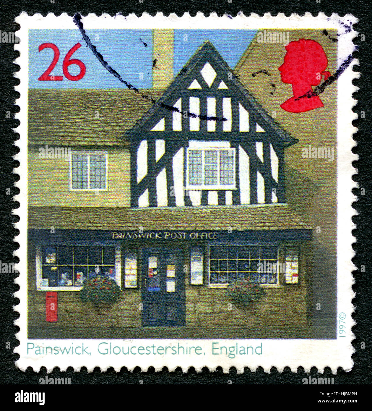Großbritannien - CIRCA 1997: Eine gebrauchte Briefmarke aus dem Vereinigten Königreich, ein Bild einer hübschen Poststelle in Painswick, Gloucestershire, ca. 1997. Stockfoto
