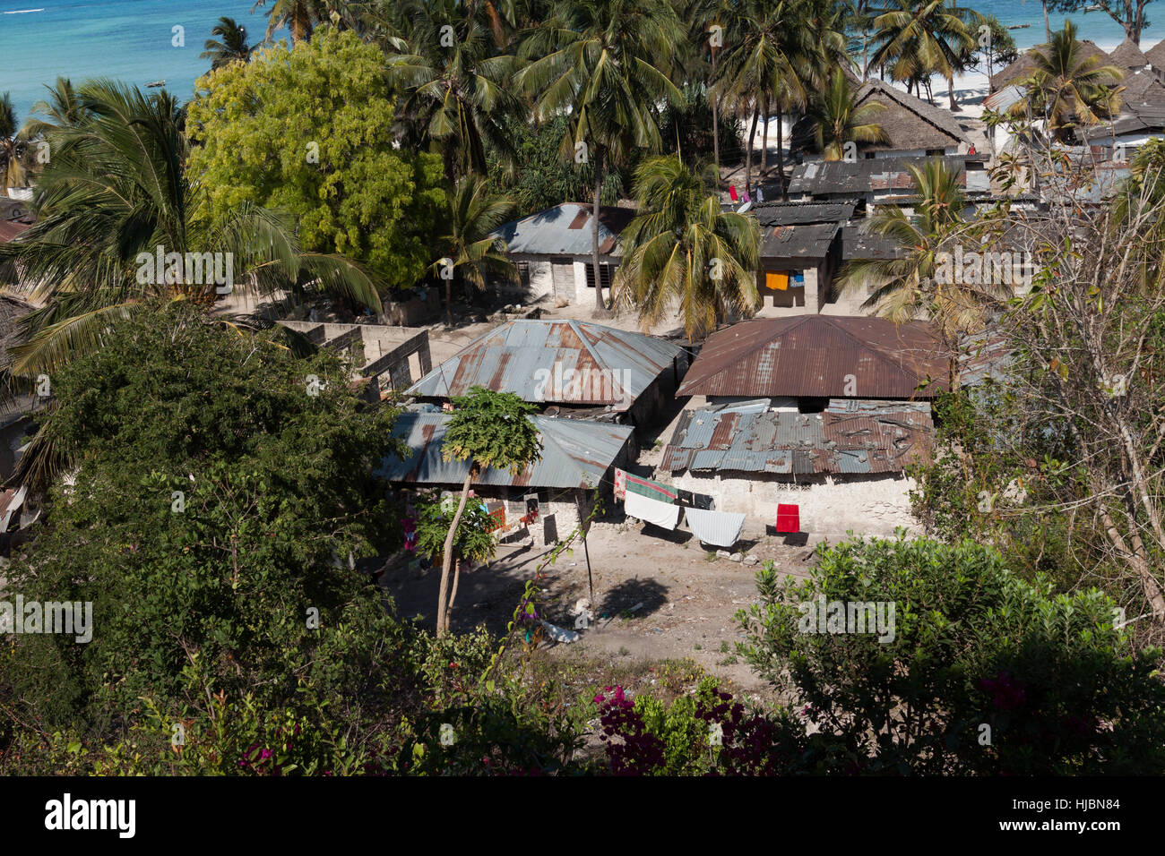 Ärmsten Teil der Küste Dorf, einfache Häuser, azurblaues Meer, Palmen im Hintergrund, sonniger Tag im Oktober, Kiwengwa, Sansibar, Tansania, Afrika Stockfoto