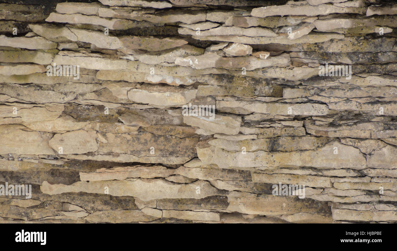 Eine Felswand Hintergrund aus verwitterten sedimentären Kalkstein mit wellenförmigen Risse drin. Stockfoto