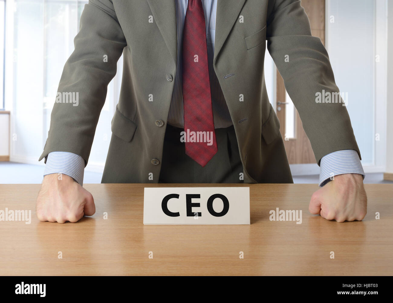 CEO, stützte sich auf den Schreibtisch im Büro Stockfoto