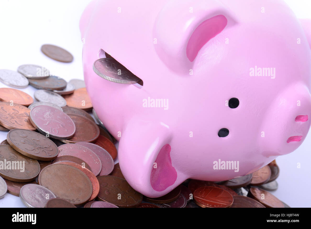 Piggy bank mit Münzen ausgießen Konzept der Schulden über gefallene oder Fragen zu finanzieren Stockfoto