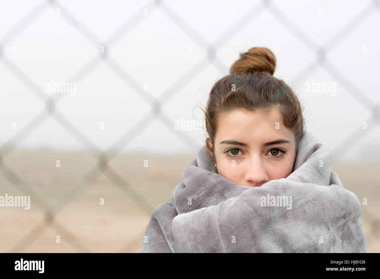 Mädchen hinter einem Zaun. Horizontalen Schuss mit natürlichem Licht. Stockfoto