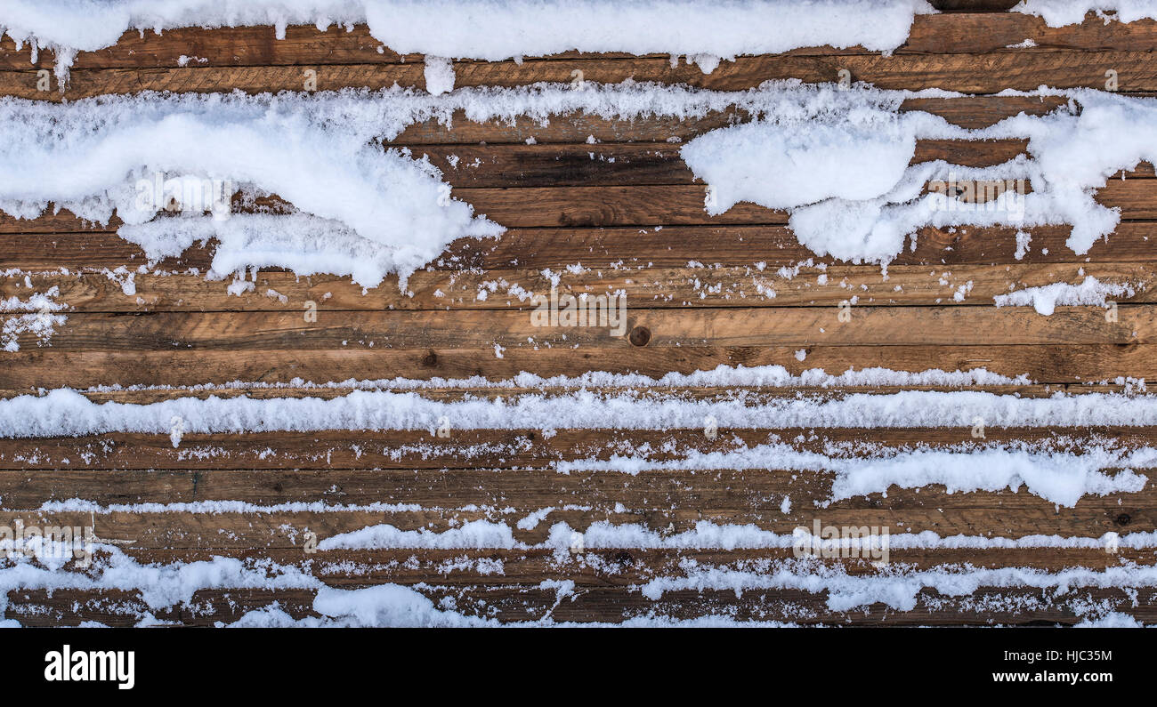 Gestapelte Holzbrettern mit Schnee bedeckt. Stockfoto