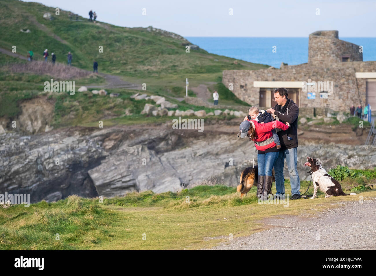 Menschen und ihren Hunden einen Spaziergang entlang der Küste Fußweg auf Towan Landzunge in Newquay, Cornwall, England. Stockfoto