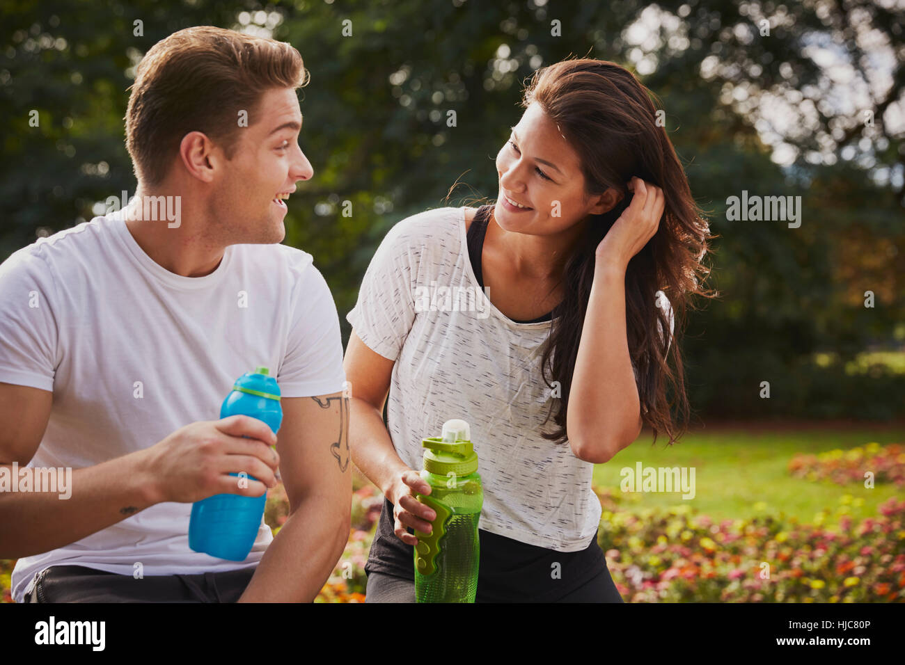 Mann und Frau training im Park, während eine Trinkpause chatten Stockfoto