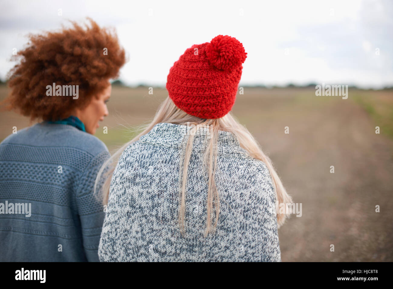 Rückansicht der beiden jungen Frauen, die einen Spaziergang im Feld Stockfoto