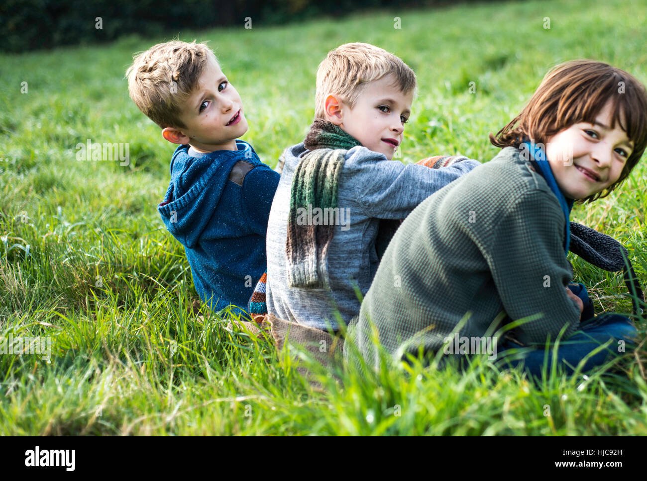 Porträt von drei jungen, sitzen zusammen im Feld, im Herbst Stockfoto