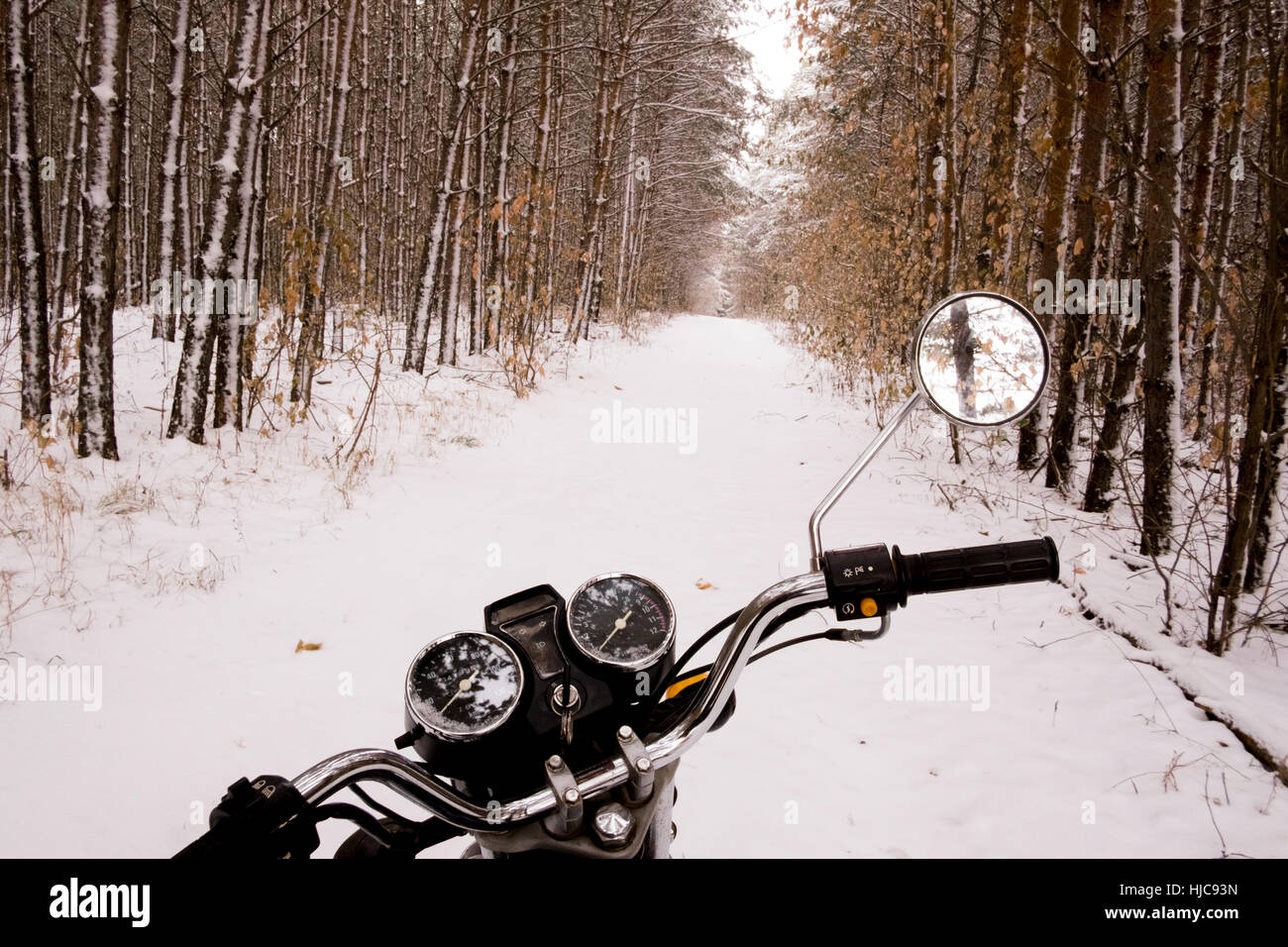 Motorrad geparkt im verschneiten Wald Stockfoto
