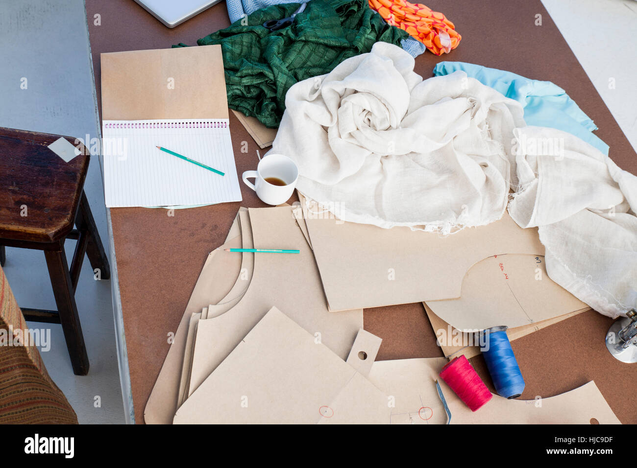 Draufsicht der Skizzenblock und Textilien auf Mode-Design-Werkstatt-Tisch Stockfoto