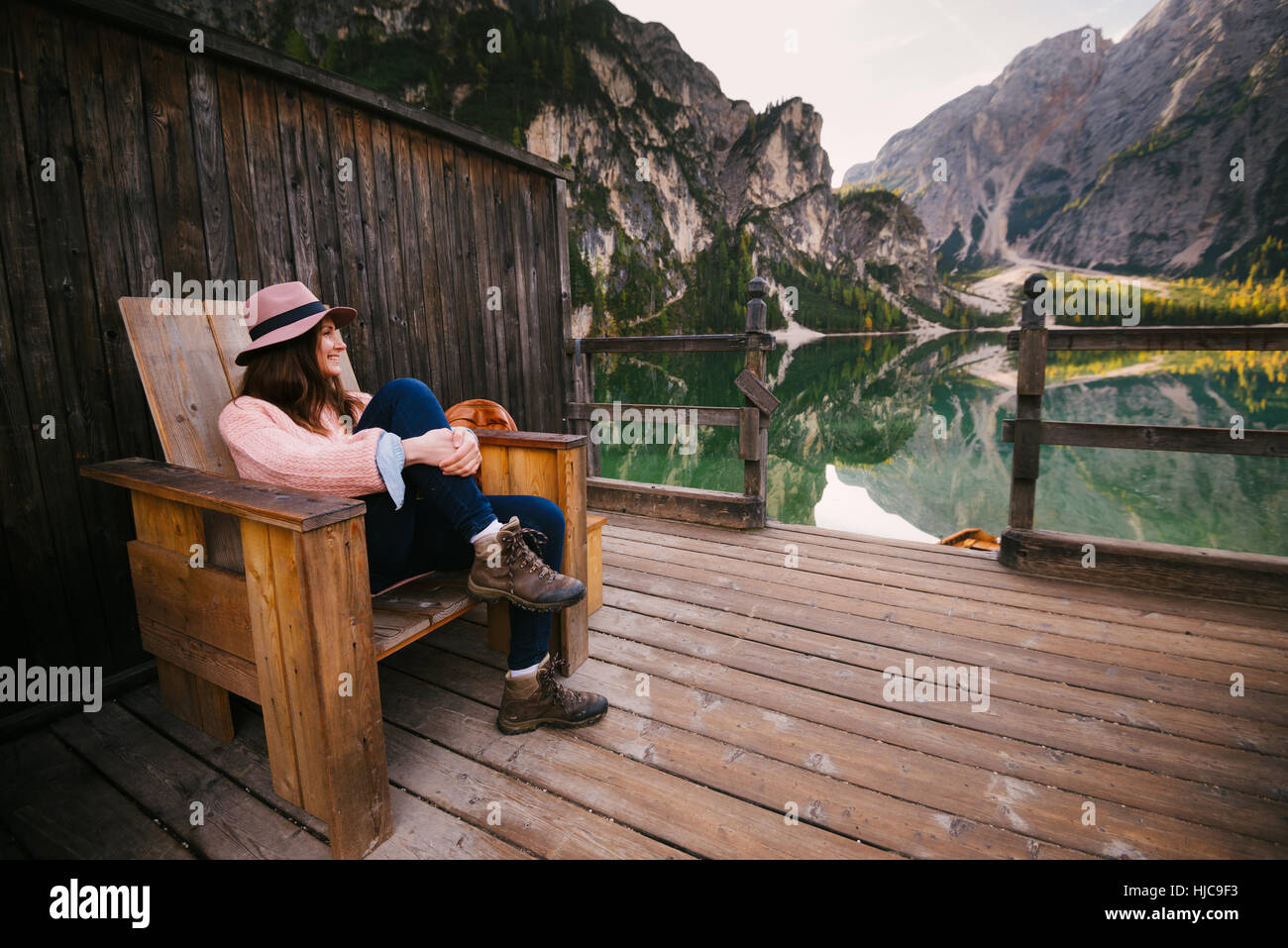 Frau, entspannend auf Holzstuhl, Lago di Braies, Val di Braies, Dolomiten, Südtirol, Italien Stockfoto