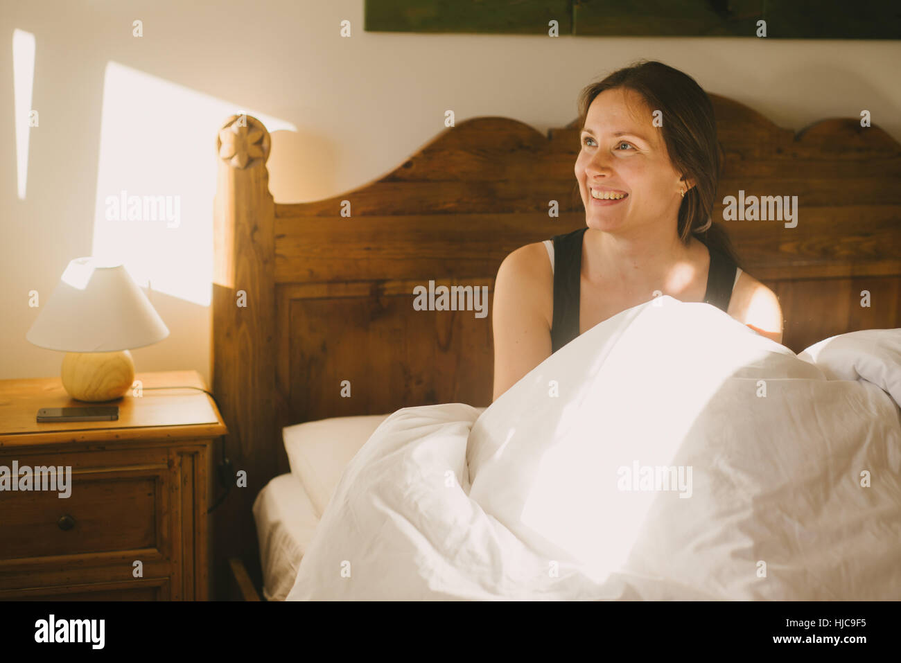 Frau lächelnd im Bett Stockfoto