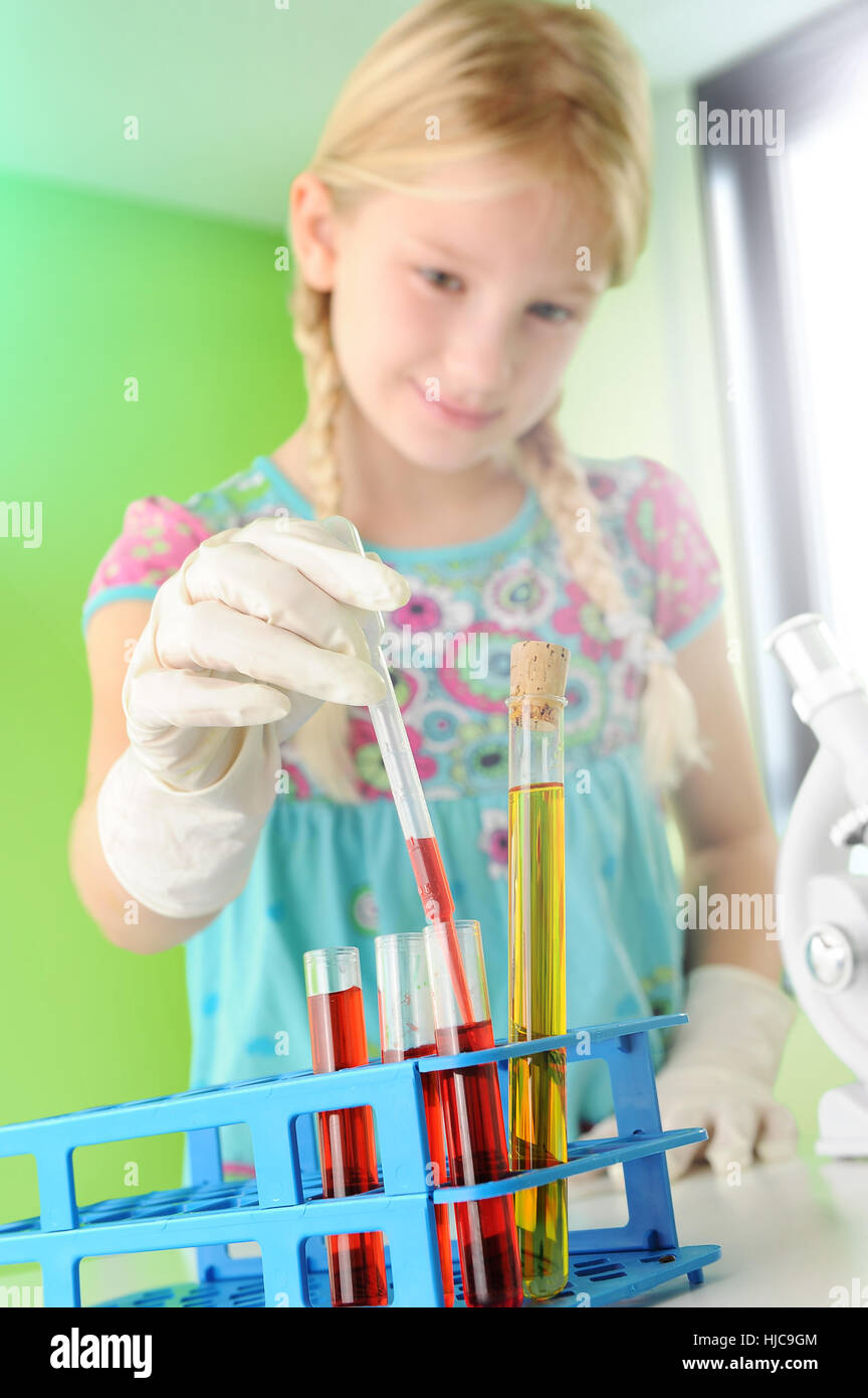 Mädchen, die vorgibt, Wissenschaftler Reagenzglas aus Rack entfernen Stockfoto