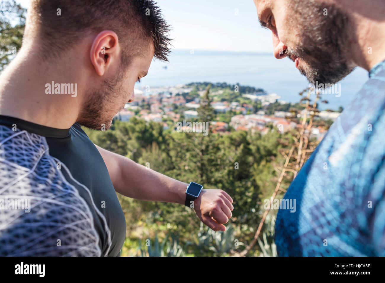 Zwei männliche Läufer Überprüfung Smartwatch im Park, Split, Dalmatien, Kroatien Stockfoto