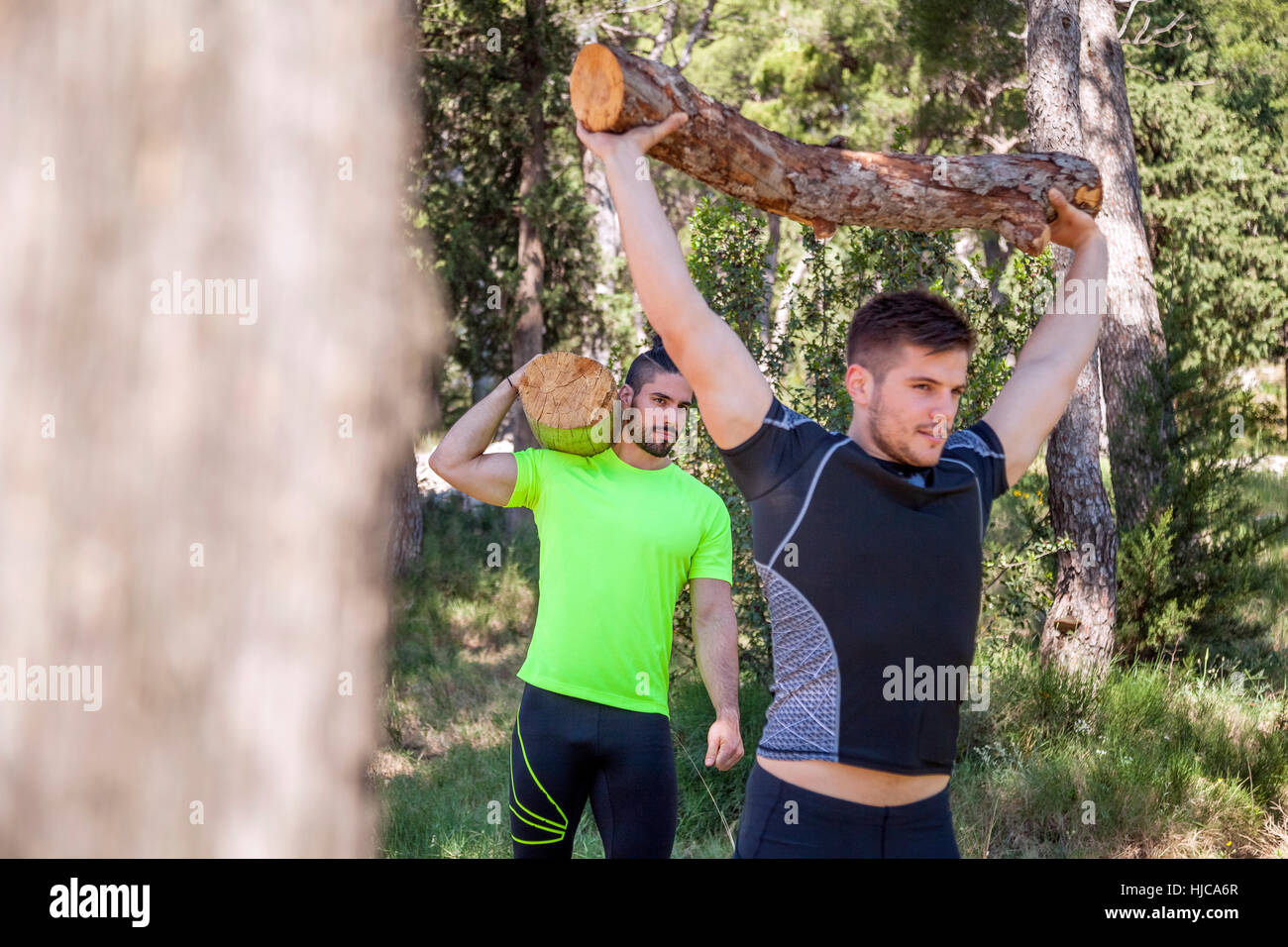 Zwei junge Männer tun Gewichtheben Training mit Baumstämme im Wald, Split, Dalmatien, Kroatien Stockfoto