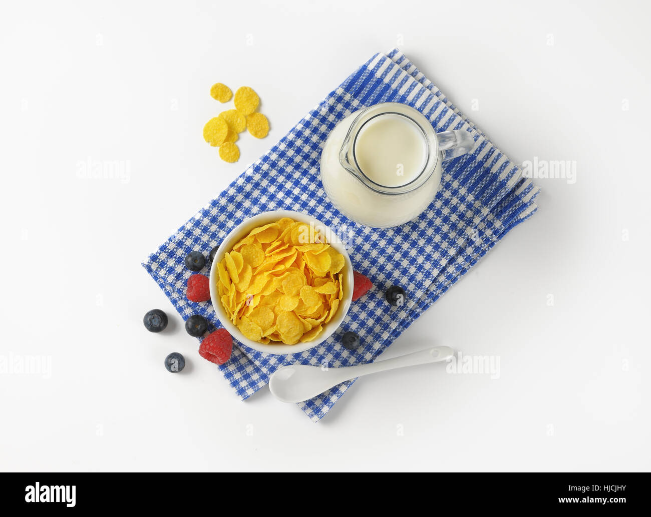 Schüssel mit Cornflakes und Milch auf kariertes Geschirrtuch Krug Stockfoto