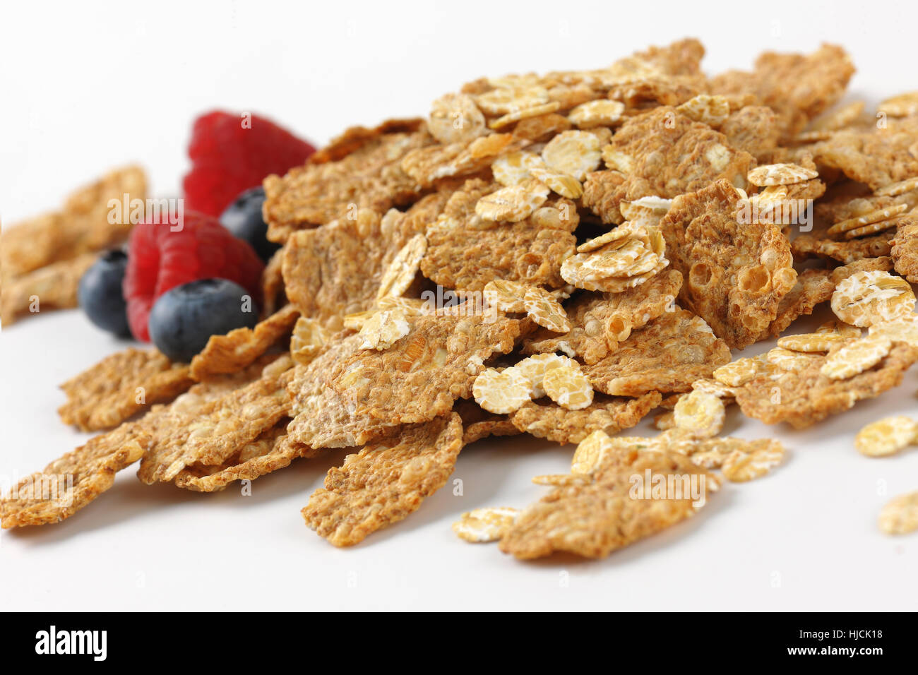 Haufen von Frühstücks-Cerealien und Berry Obst auf weißem Hintergrund - Nahaufnahme Stockfoto