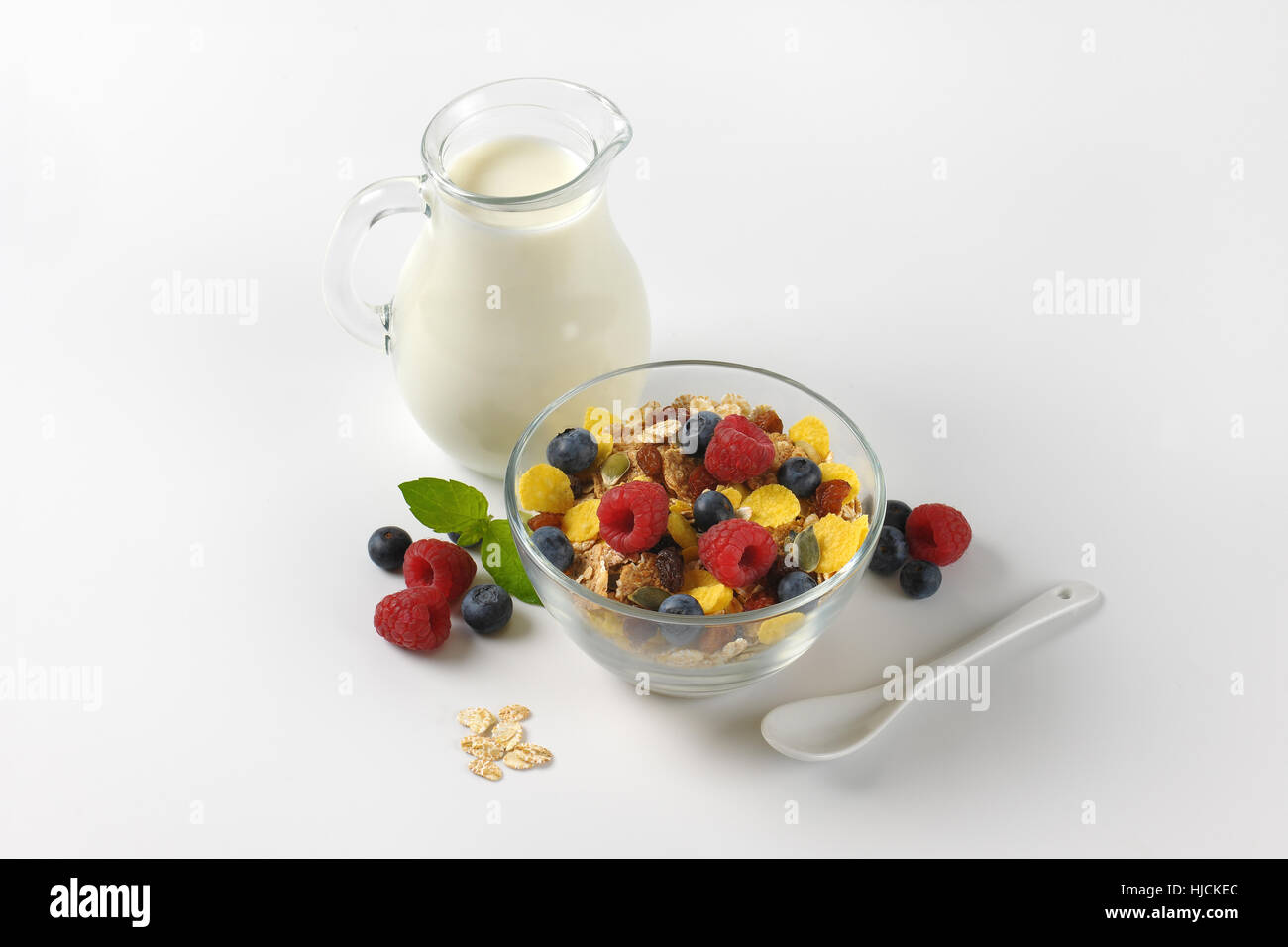 Schüssel mit Getreide und Beerenfrucht mit Milchkanne Milch Stockfoto