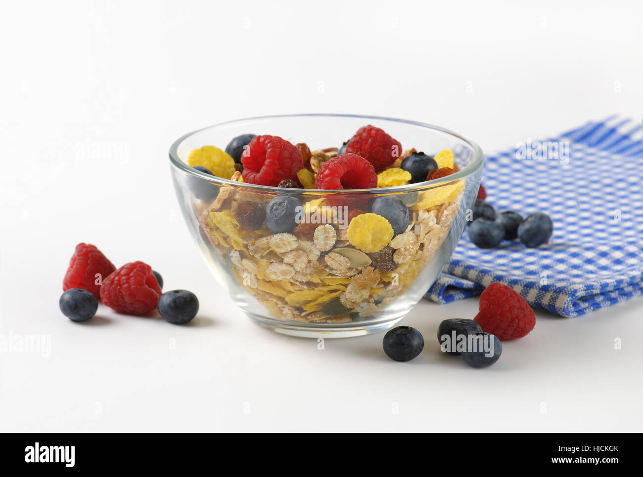Schüssel mit Getreide und Beerenfrucht und karierte Serviette Stockfoto