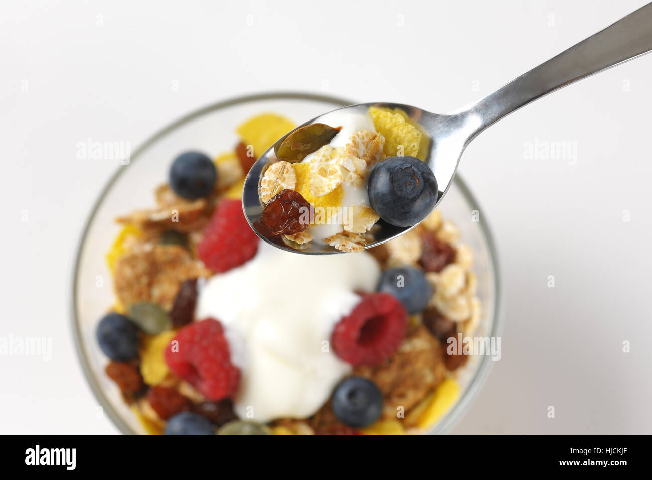 Schüssel und Löffel Müsli mit Beeren, Obst und Joghurt - Nahaufnahme Stockfoto