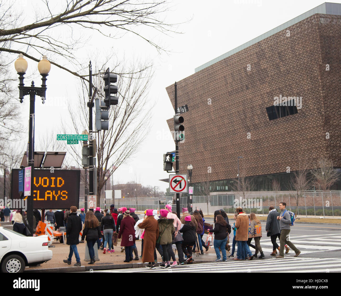 Washington, USA. 21. Januar 2017. Frauen Marsch auf Washington, DC: Frauen und Männer jeden Alters anziehen rosa Hut Kreuzung Constitution Avenue mit dem neuen African American Museum im Hintergrund, die Rallye-Website, um Präsident Trump Positionen zur Frauen- und anderer Menschenrechte protest zu erreichen. Bildnachweis: Dasha Rosato/Alamy Live-Nachrichten Stockfoto