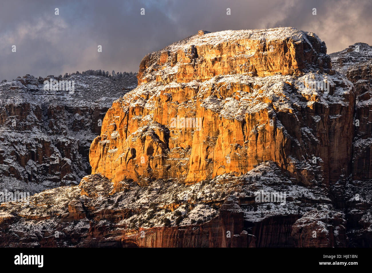 Dramatisches Sonnenlicht auf schneebedeckten Felsformationen in Sedona, Arizona Stockfoto
