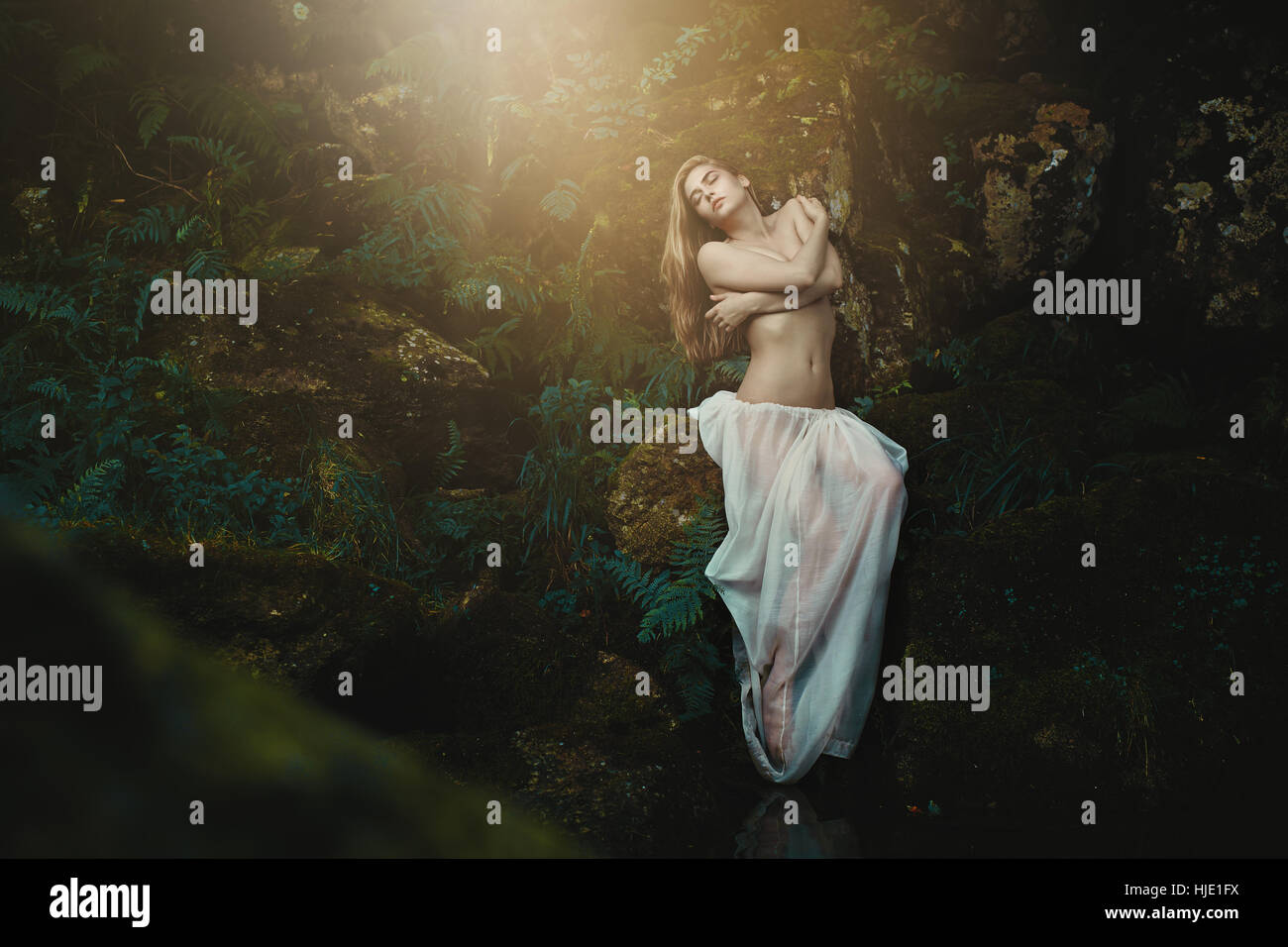 Schönen Waldnymphe unter den Farnen. Fantasie und Romantik Stockfoto