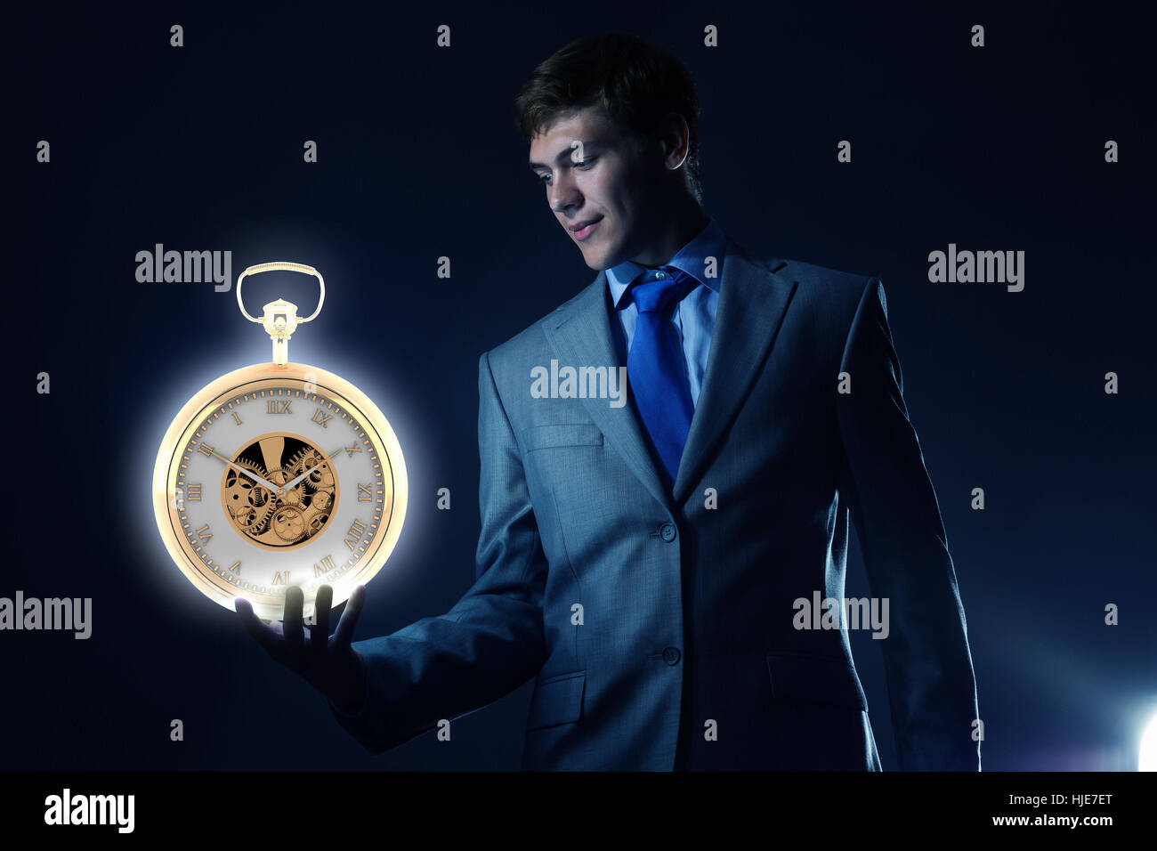 Junger Geschäftsmann hält Taschenuhr in der hand Stockfoto