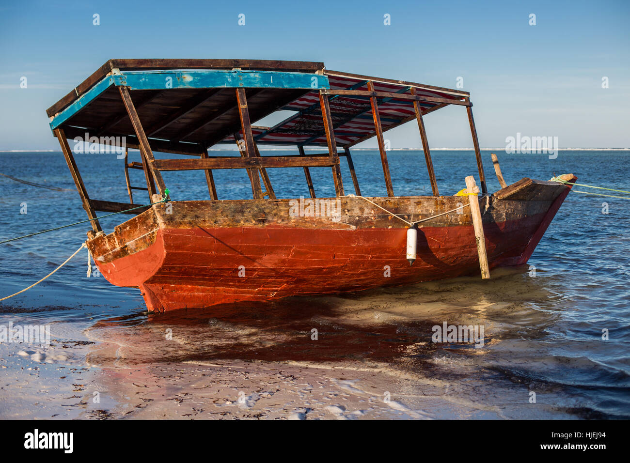 Einfache Touristenboot mit Dach am Meer, in der Regel verwendet für Schnorcheln, blauer Himmel, Indischer Ozean, Matemwe, Zanzibar, Tansania, Afrika Stockfoto