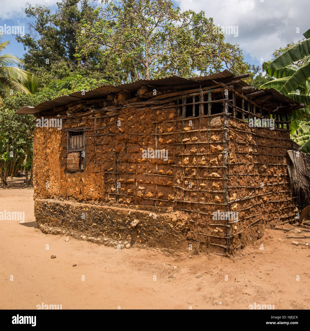 Primitive Häuschen mit Stahlblech-Dach, gebaut von lokalen Ureinwohner, ausgefertigt von Holzstäbchen und roter Erde (keine Ziegel), Uzi Island, Zanzibar, Tan Stockfoto