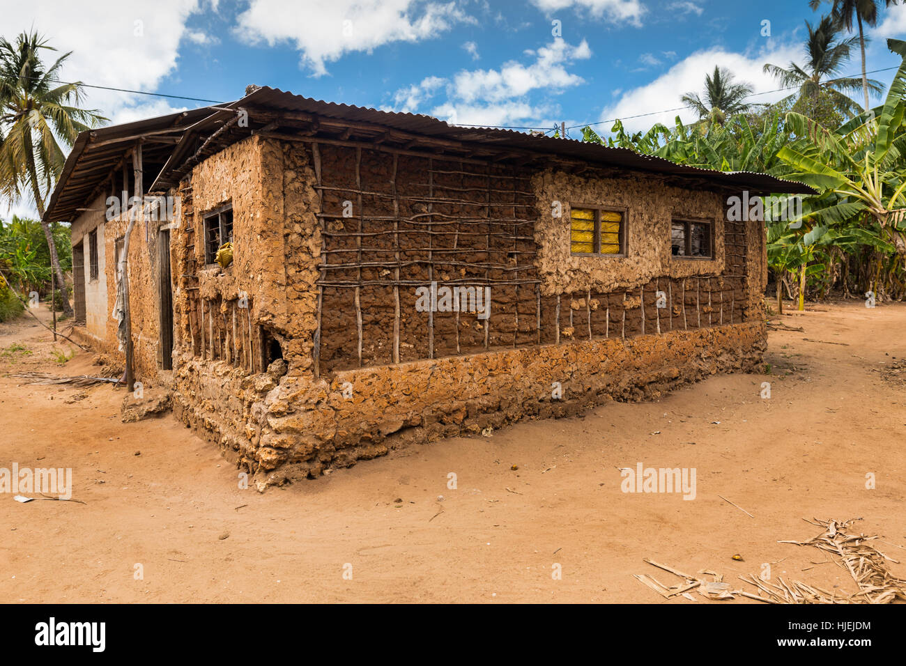 Großen primitive Haus mit Stahlblech-Dach, gebaut von einheimischen lokalen armen Menschen, gemacht aus Holzstäbchen und roter Erde (keine Ziegel), Uzi Island, Zanzibar, Stockfoto