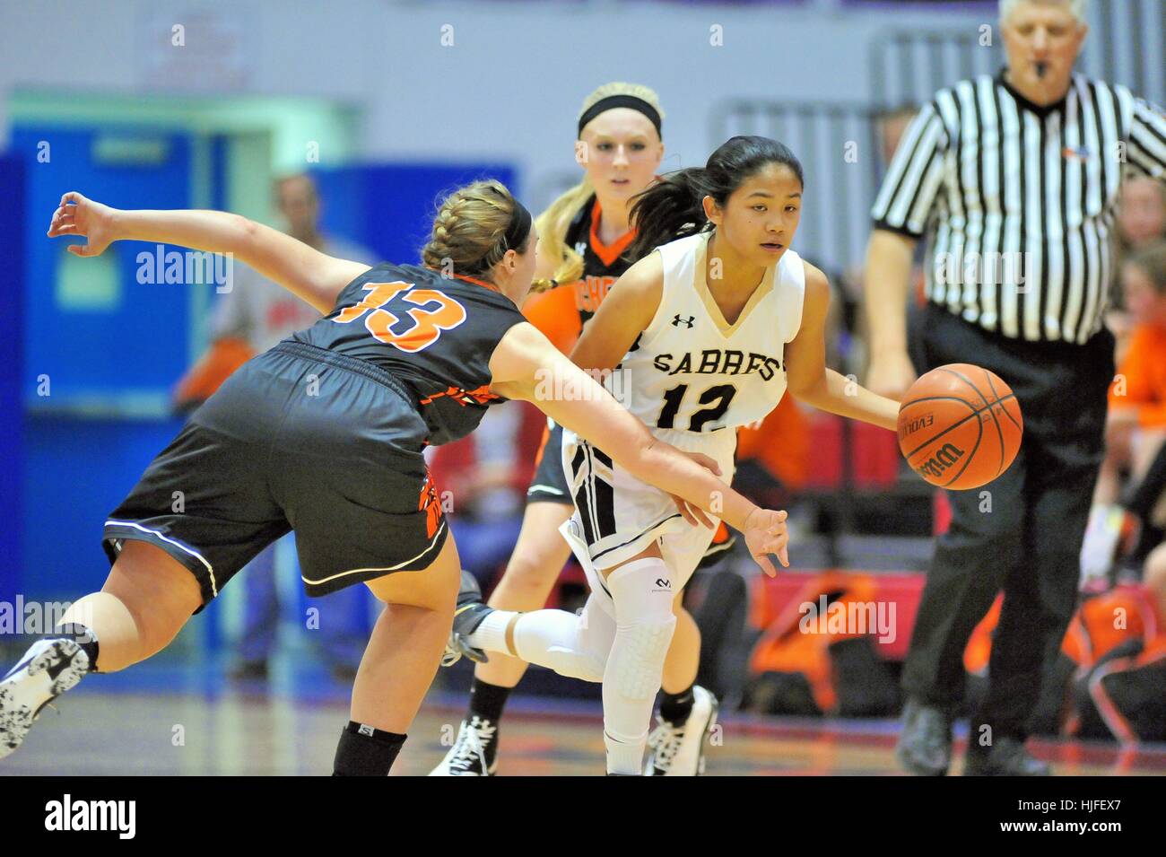 Point Guard Vorbeifahren ein Verteidiger beim Versuch, die Handlung während einer High School Basketball Spiel zu setzen. USA. Stockfoto